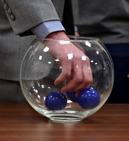 процесс жеребьевки с шарами и флагами на столе